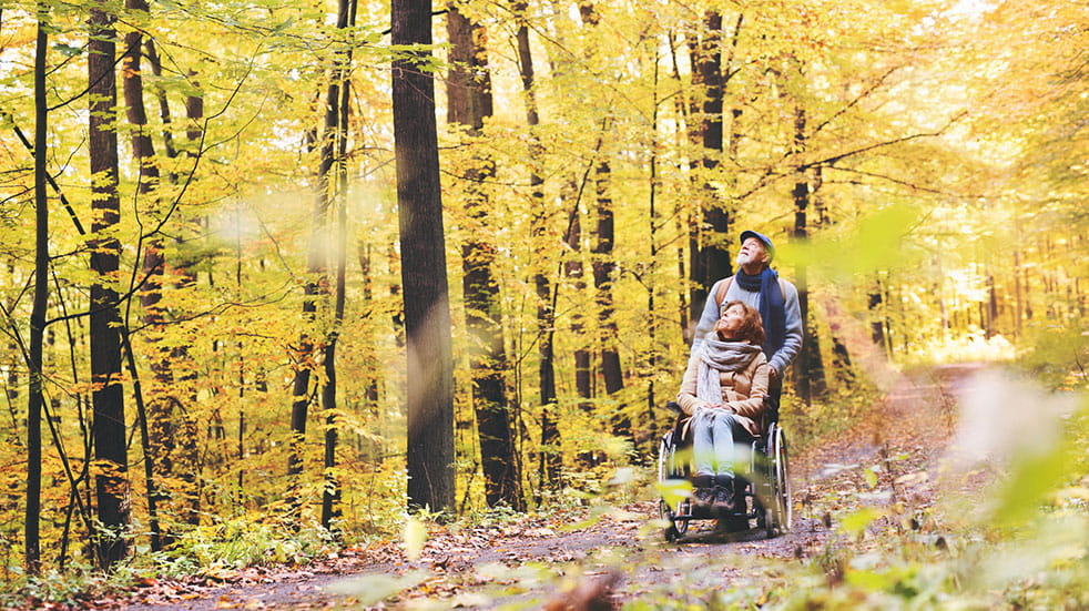 Six of the best European travel destinations man pushing woman in wheelchair through forest